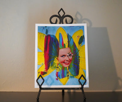 Colorful abstract painting of a person on an easel against a plain wall.