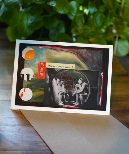 Artistic card with abstract design and text on a wooden surface with greenery in the background