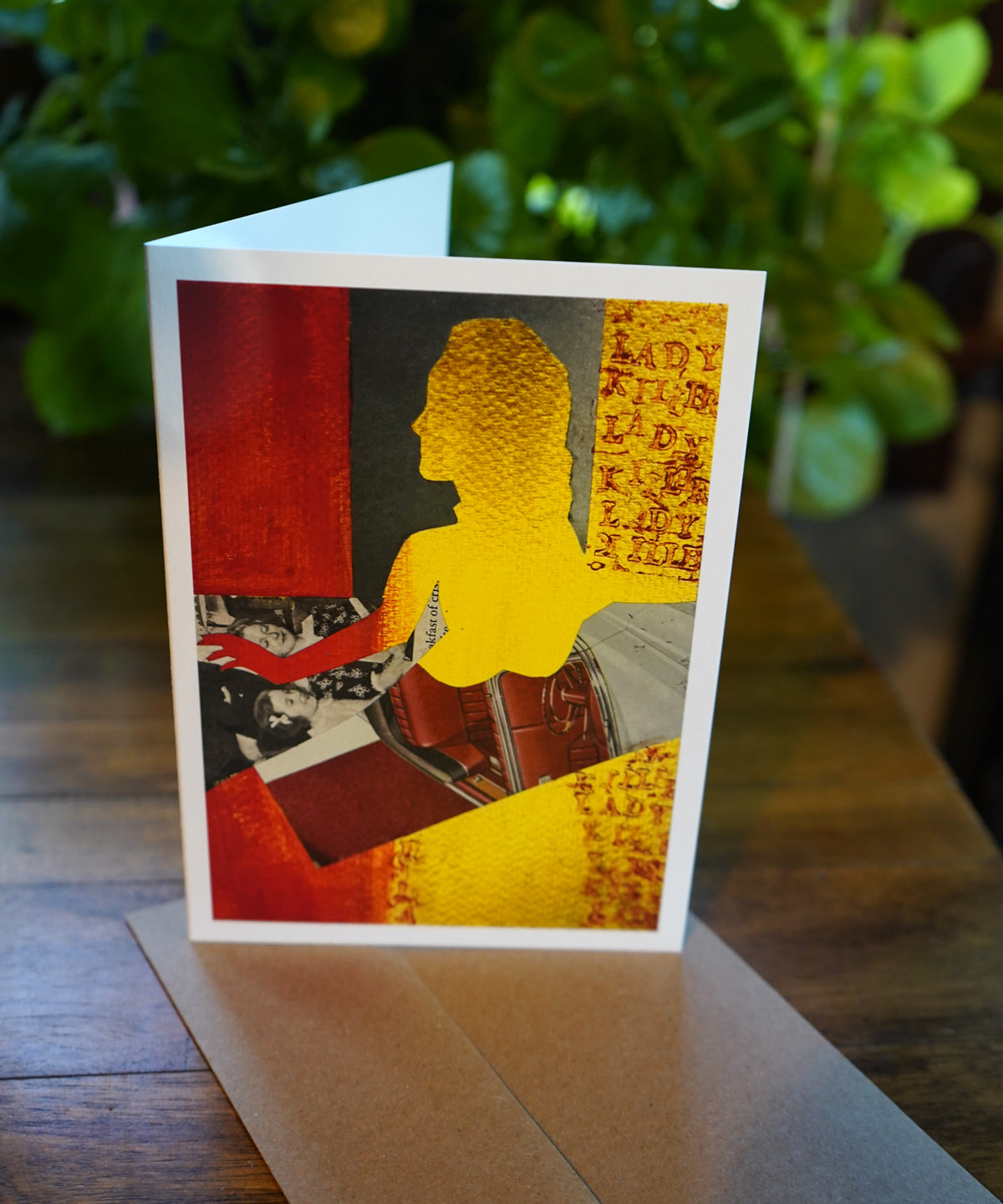 Greeting card with silhouette of awoman in gold and red with the words lady killer lady stamped on the side