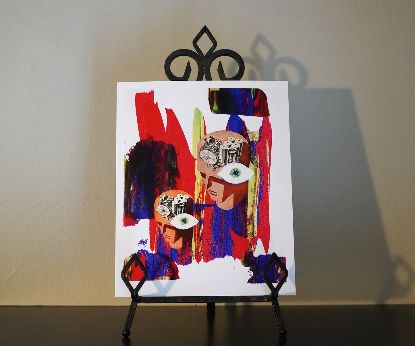 Abstract artwork on a small easel against a plain wall