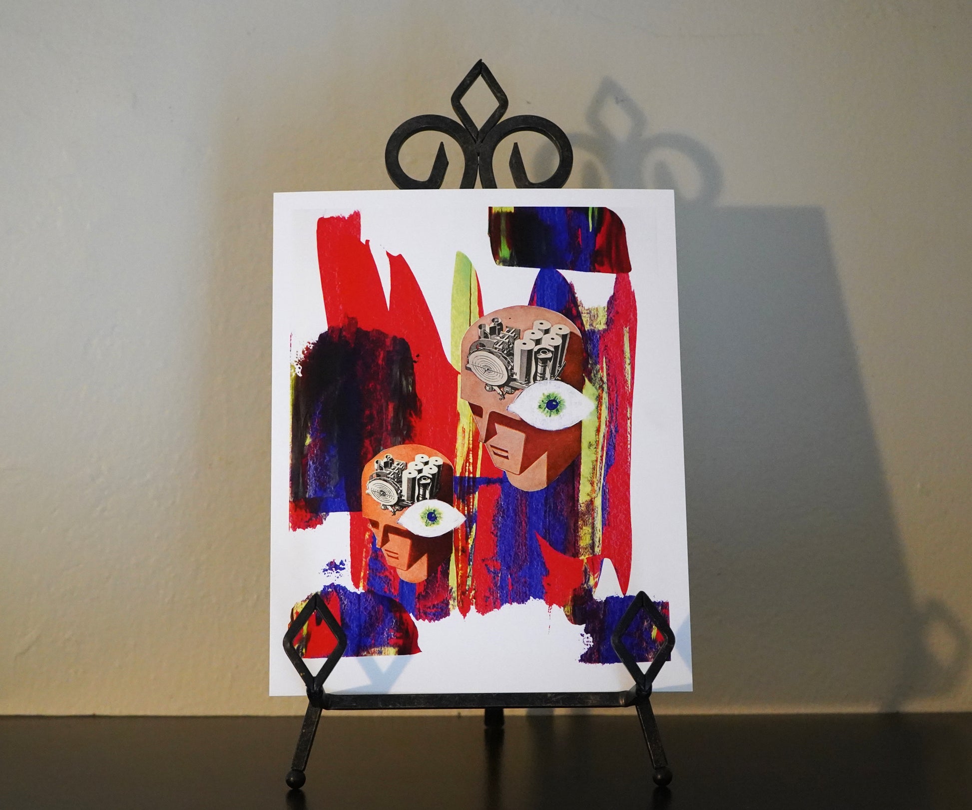 Abstract artwork on a small easel against a plain wall