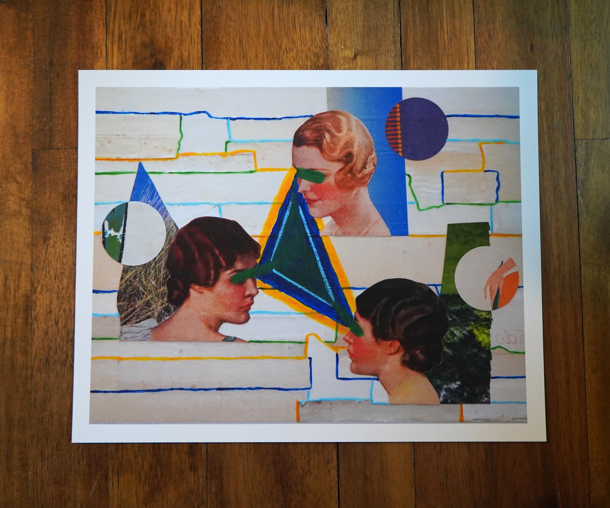 Collage art with abstract shapes and portraits on a wooden surface