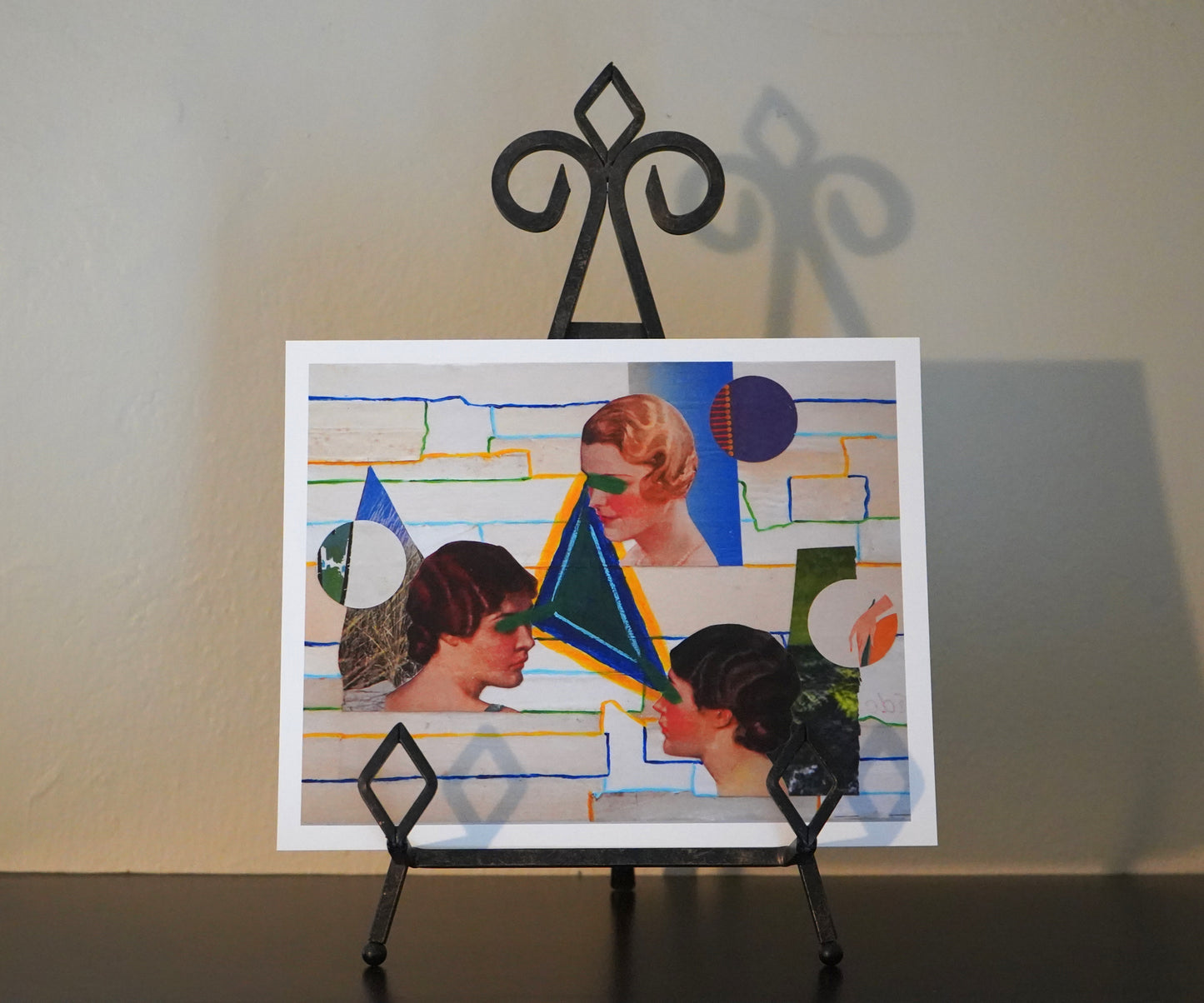Collage art piece with geometric shapes and abstract design on a stand.